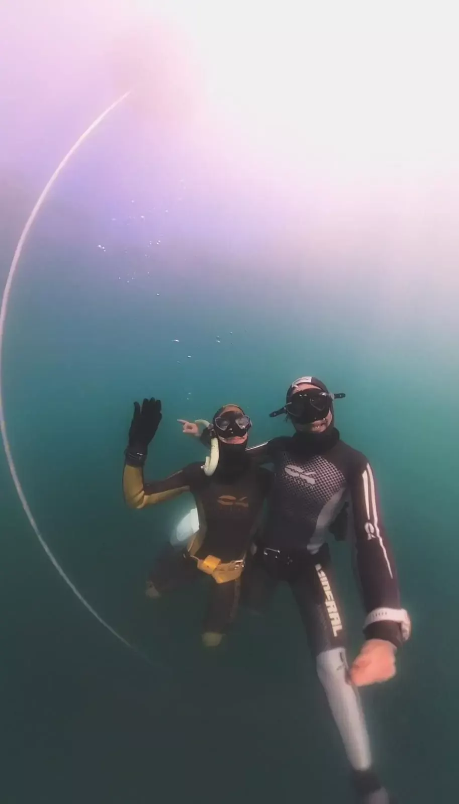 Deux apnéistes saluent sous l’eau en milieu naturel