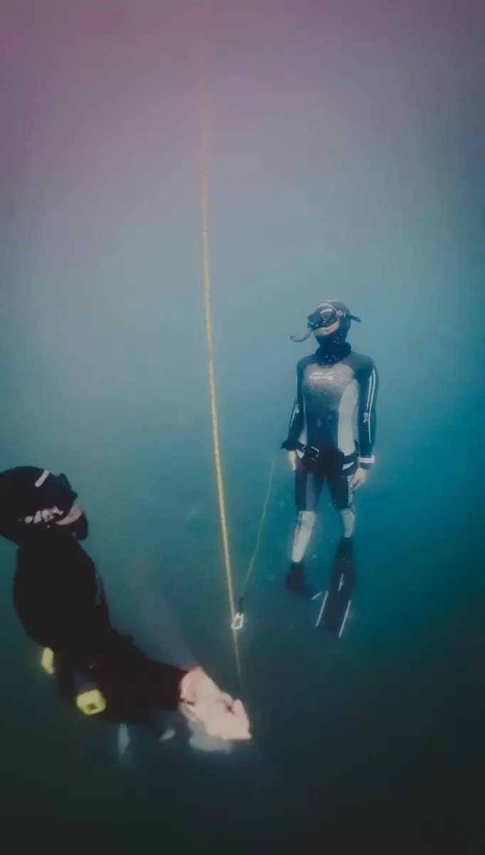 Deux apnéistes en eau profonde, à côté du câble de descente