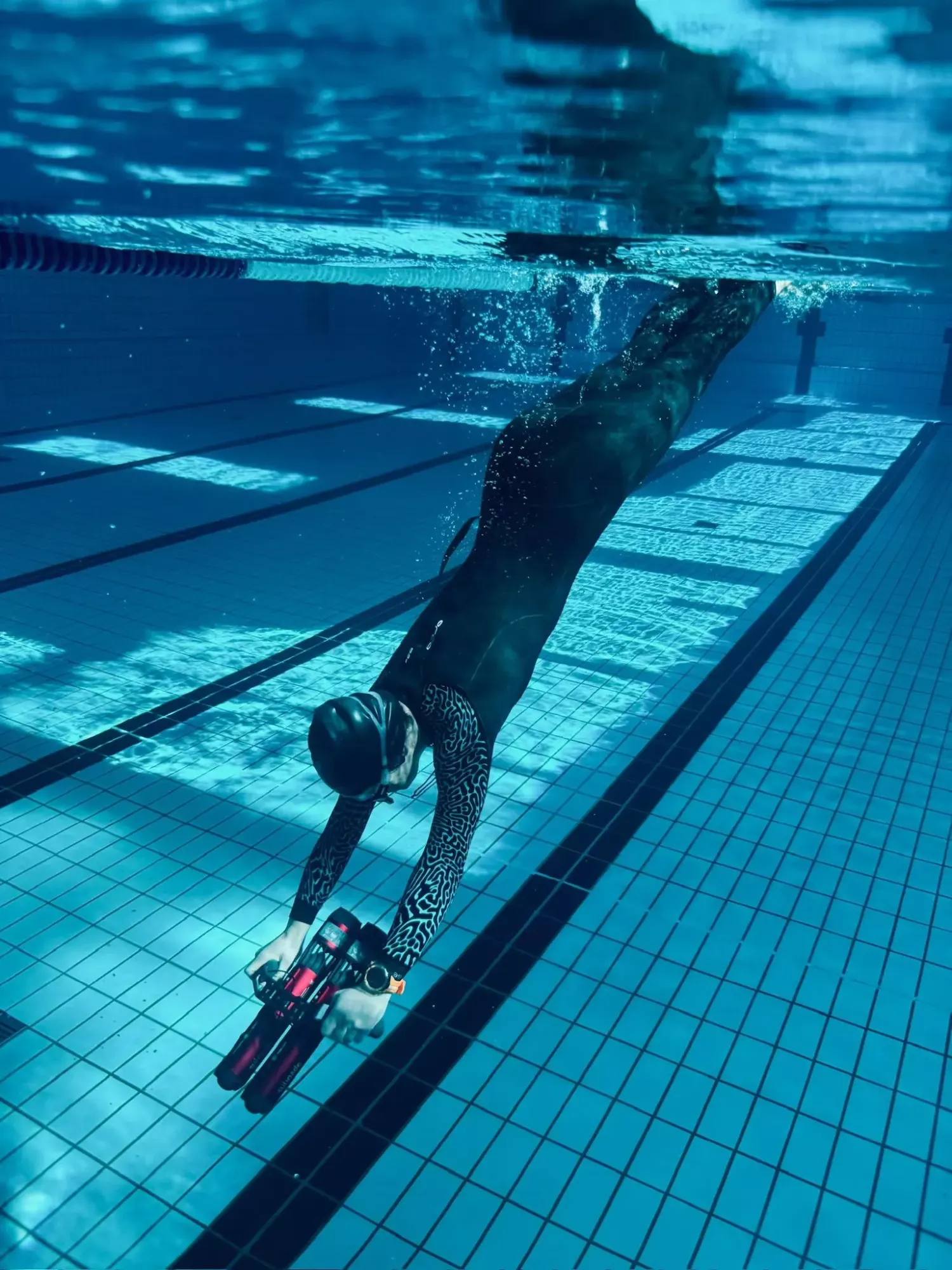 Apnéiste plongeant vers le fond de la piscine