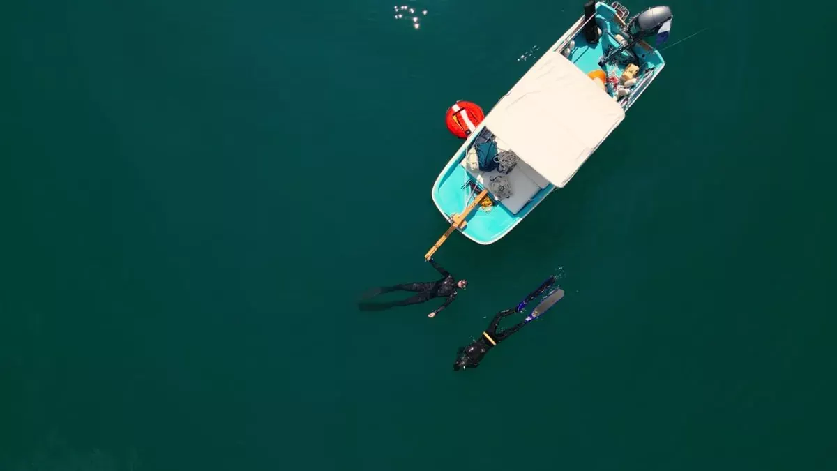 Vue aérienne du bateau du club sur le lac avec deux apnéistes
